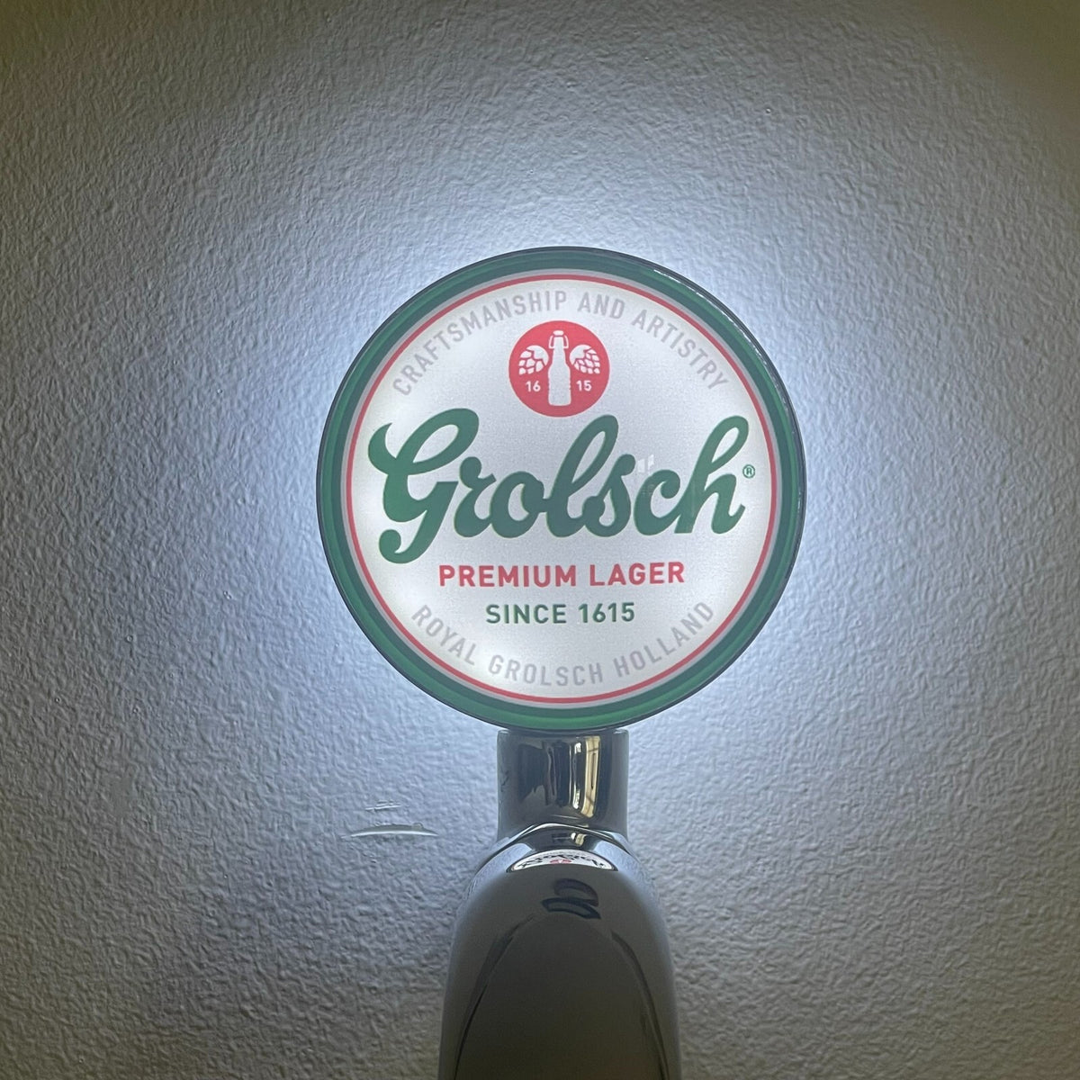 Grolsch Premium Pilsner badge lit up on a beer tap