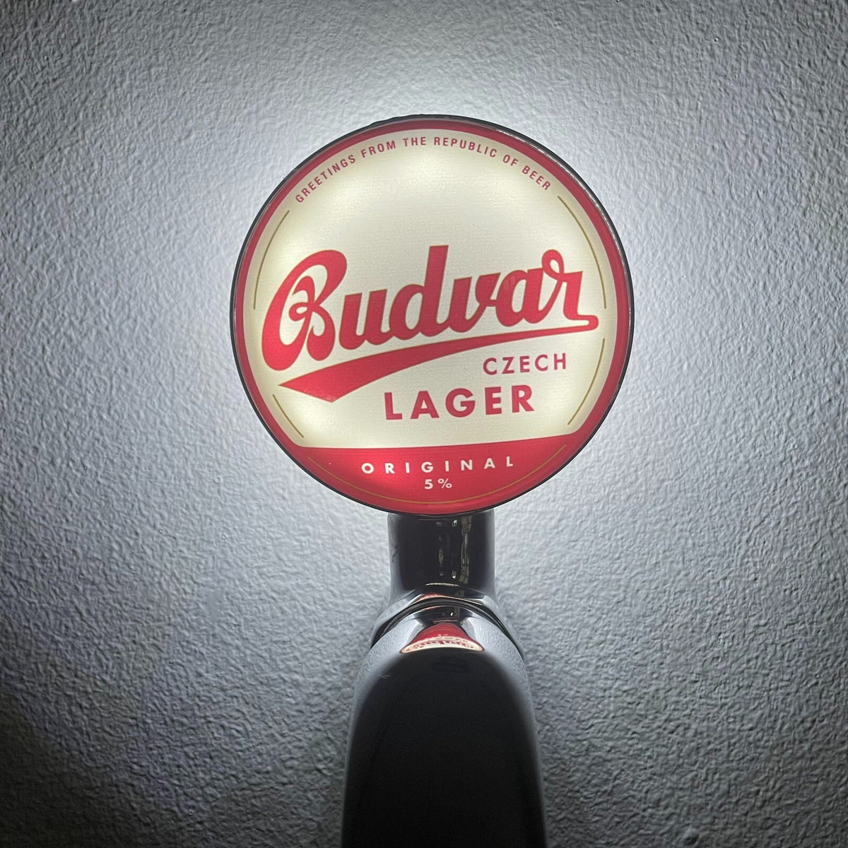 Budvar badge lit up on a beer tap