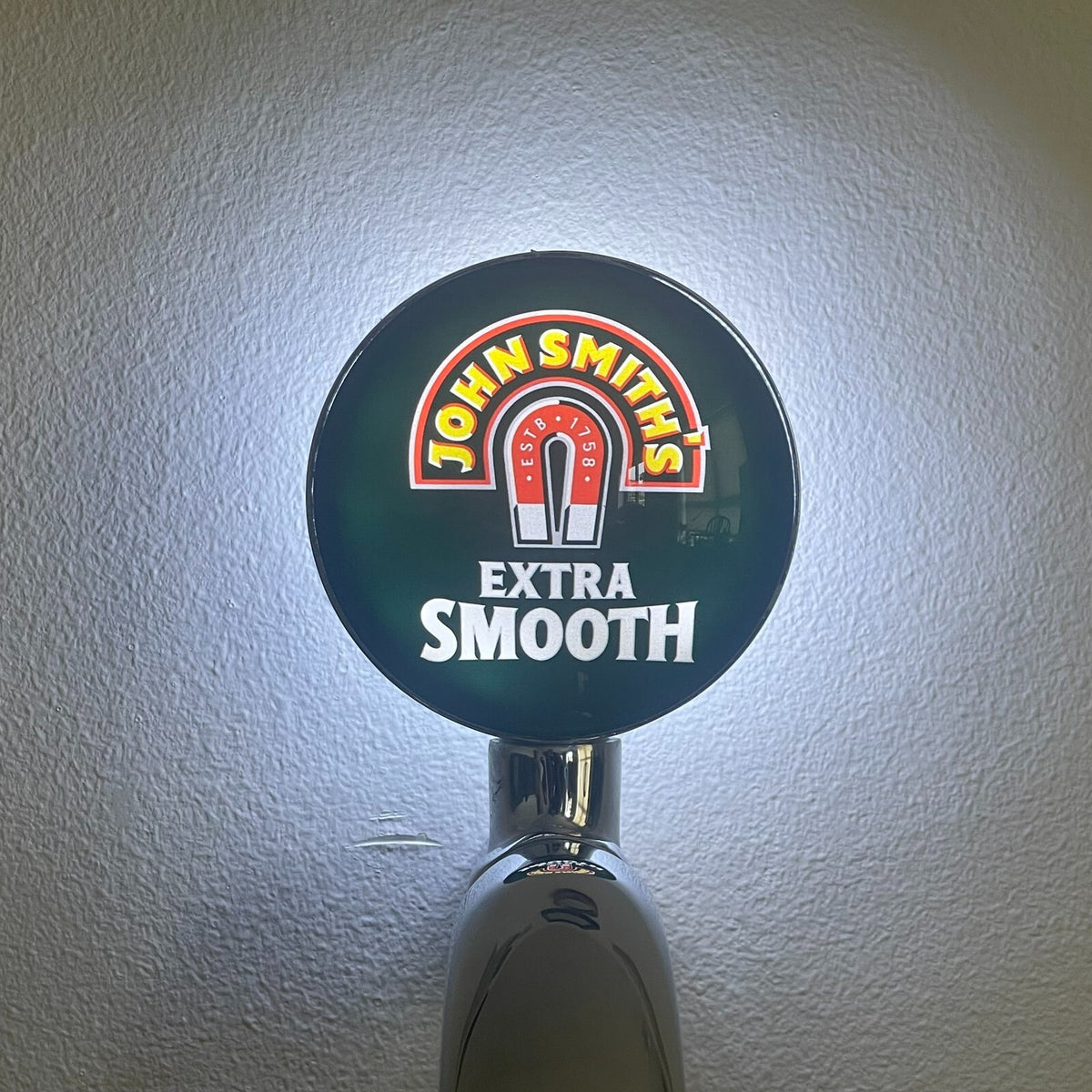 John Smith's Extra Smooth badge lit up on a beer tap