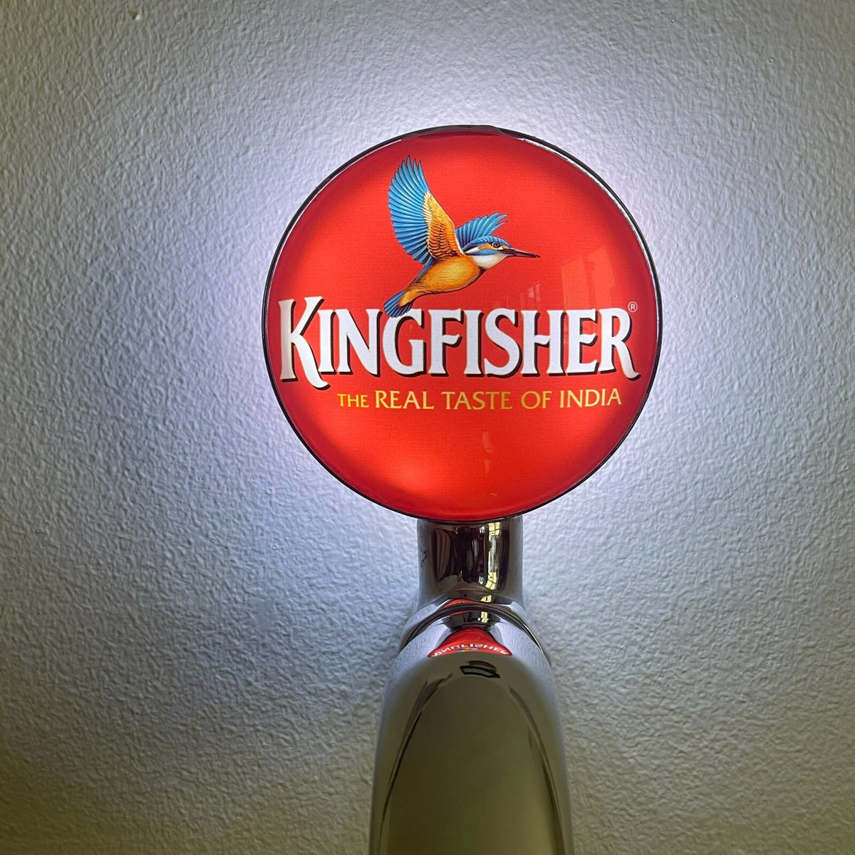 Kingfisher badge lit up on a beer tap