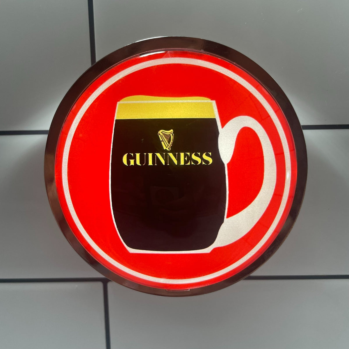 Retro Red Guinness (1960s) badge lit up on a beer tap