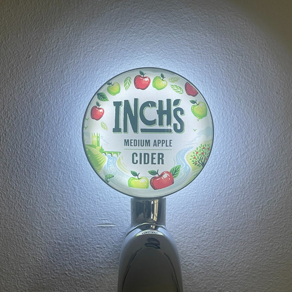 Inch's Cider badge lit up on a beer tap