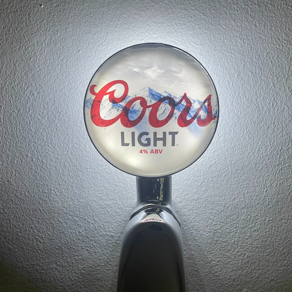 Coors Light badge lit up on a beer tap