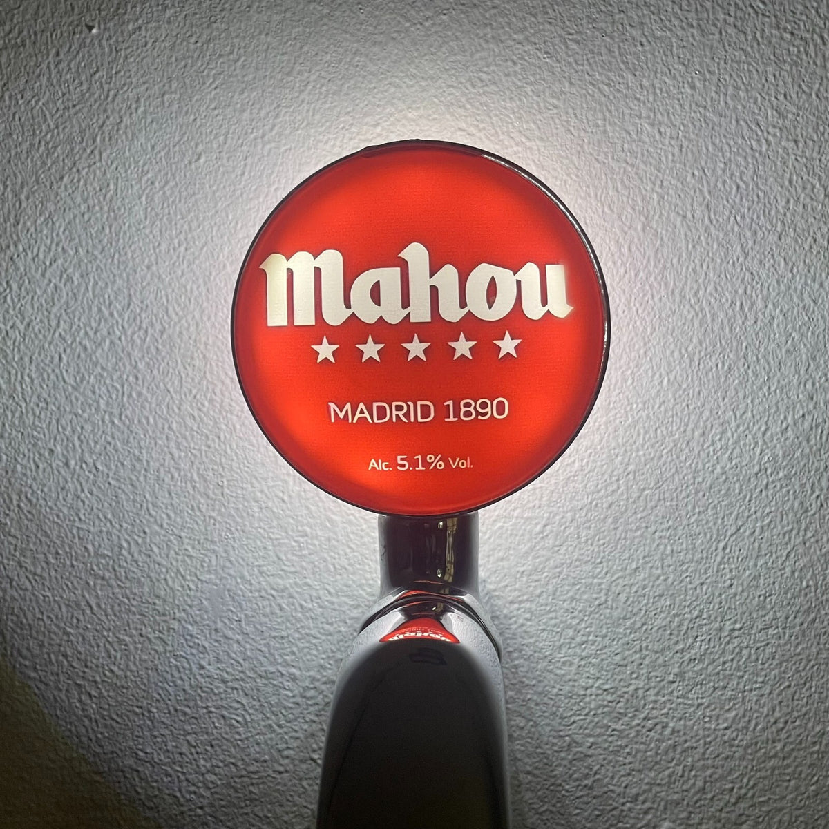 Mahou badge lit up on a beer tap
