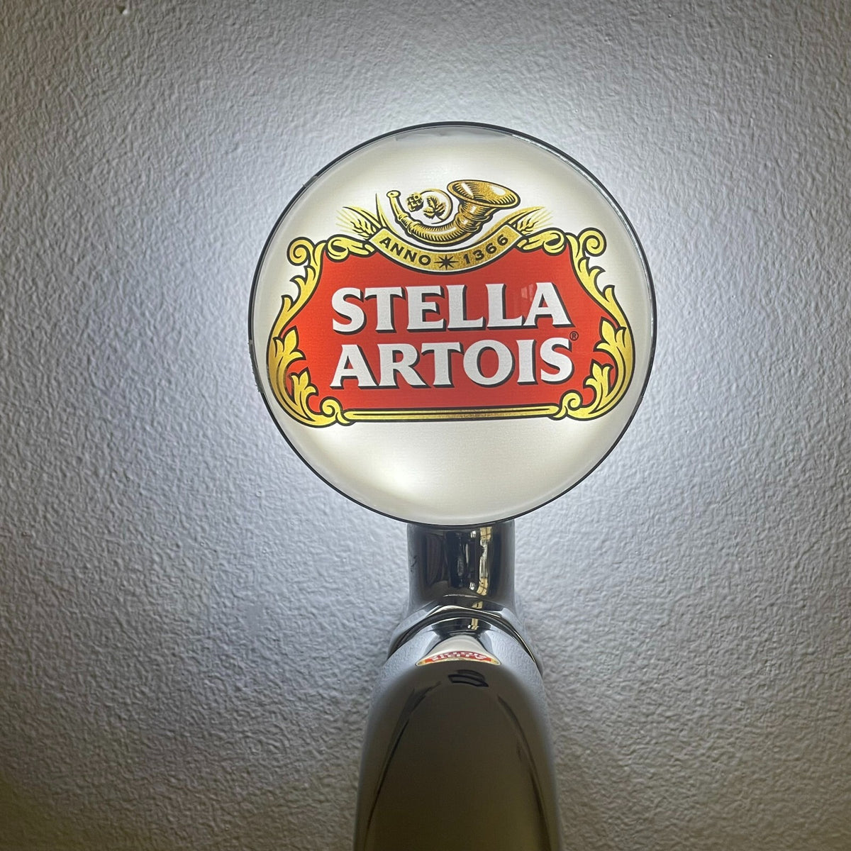 Stella Artois badge lit up on a beer tap