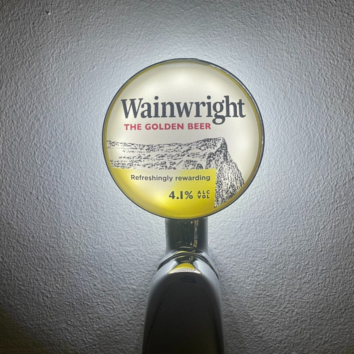 Wainwright badge lit up on a beer tap