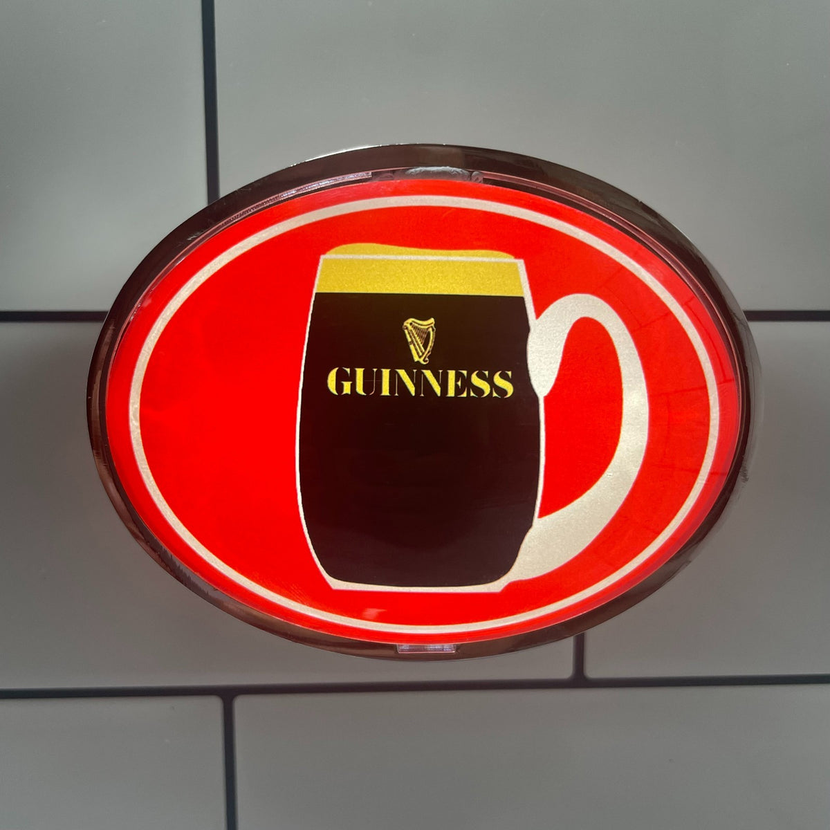 Retro Red Guinness (1960s) oval badge lit up on a beer tap