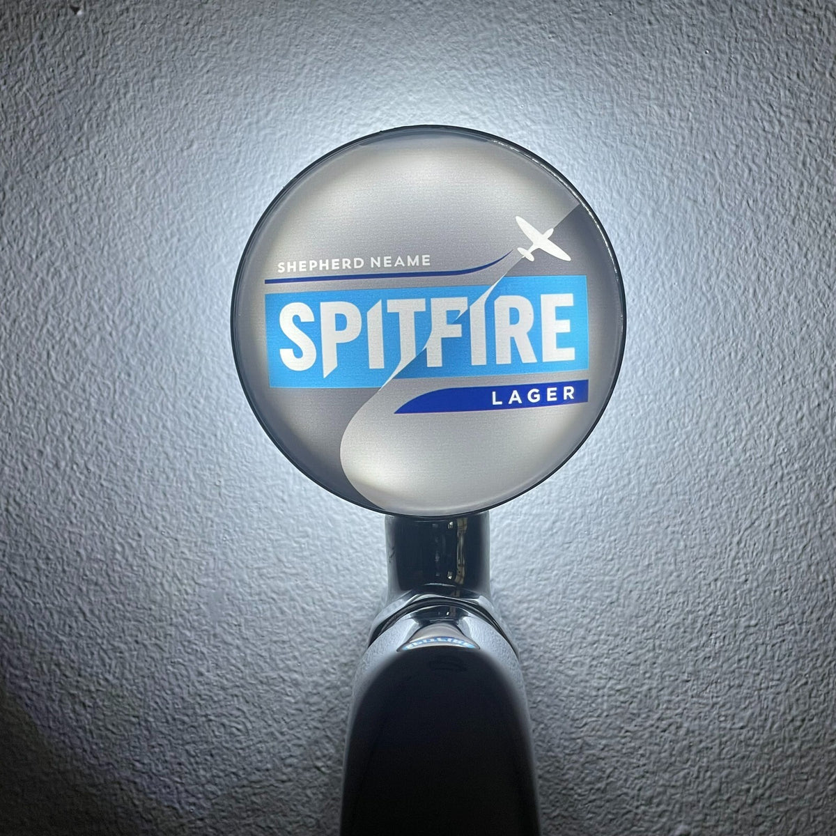 Spitfire Lager badge lit up on a beer tap