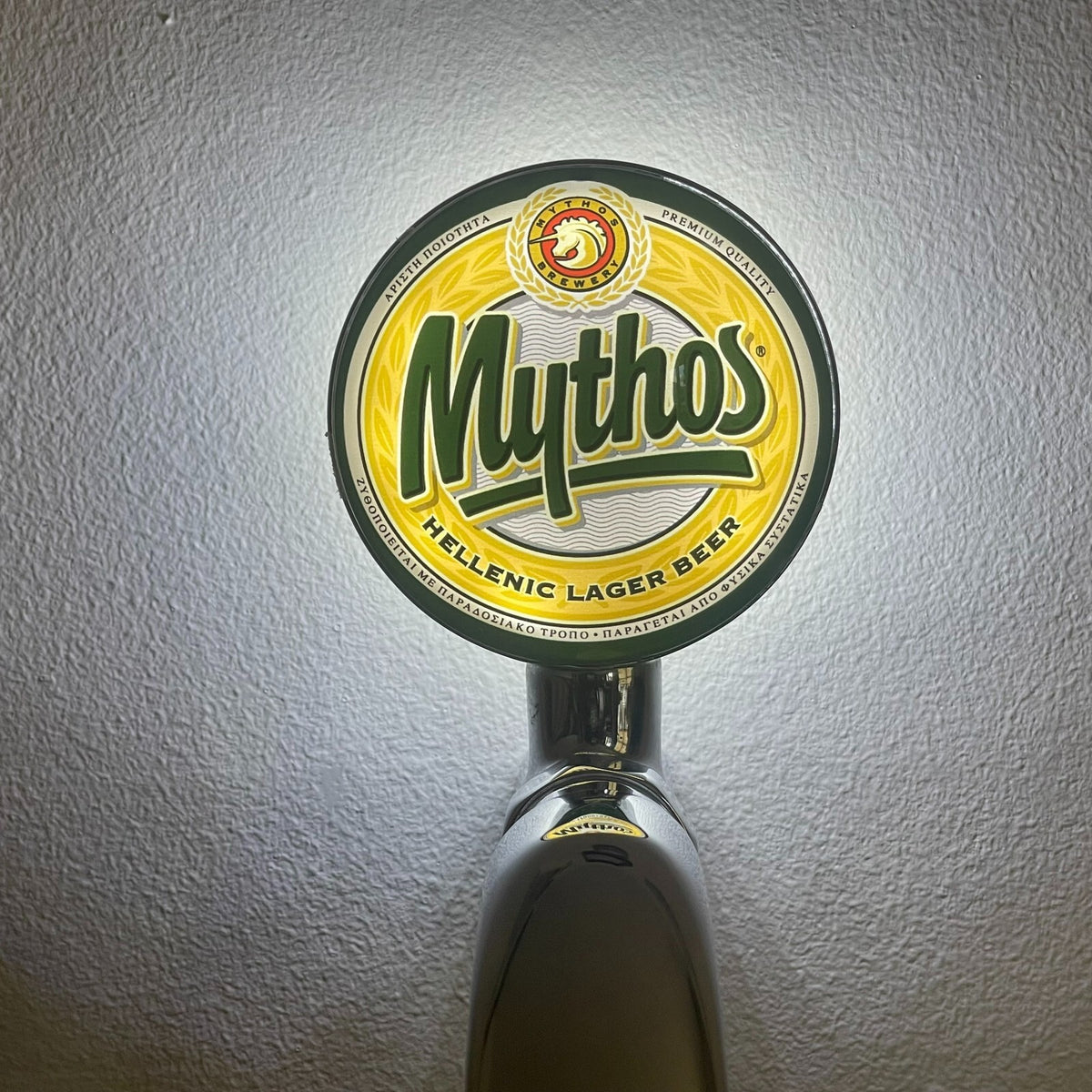 Mythos badge lit up on a beer tap