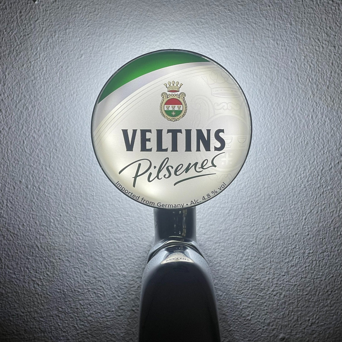 Veltins badge lit up on a beer tap