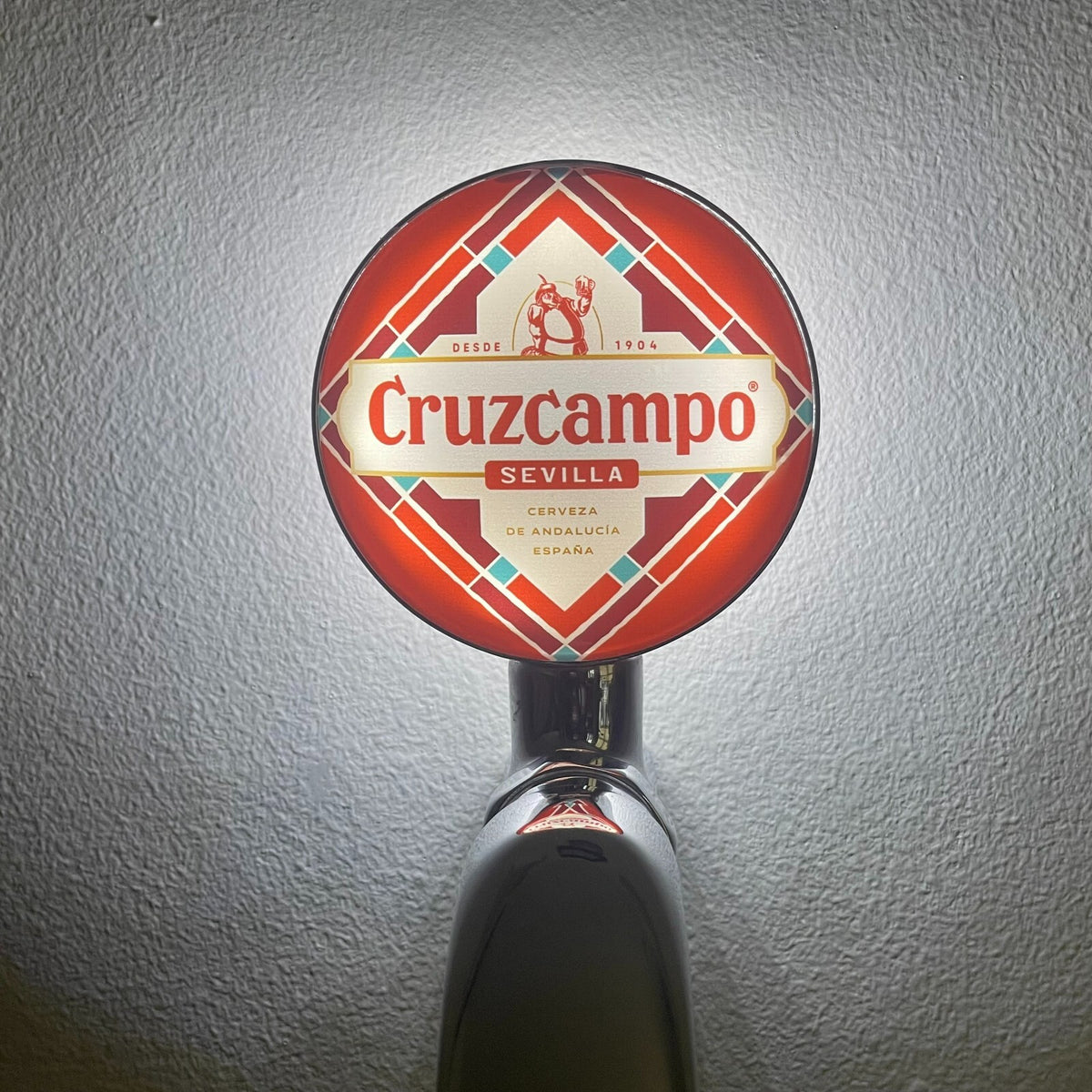 Cruzcampo badge lit up on a beer tap