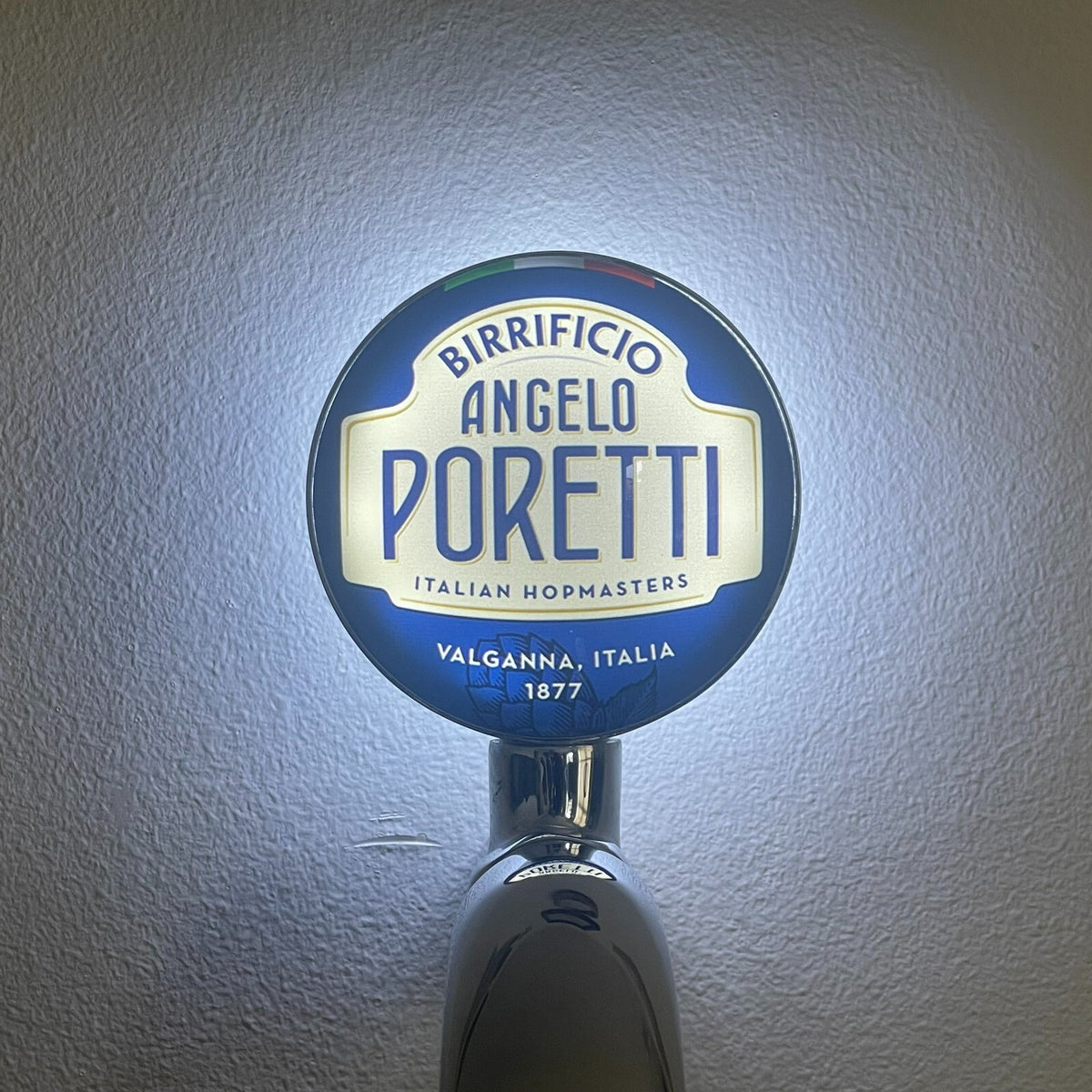 Poretti badge lit up on a beer tap