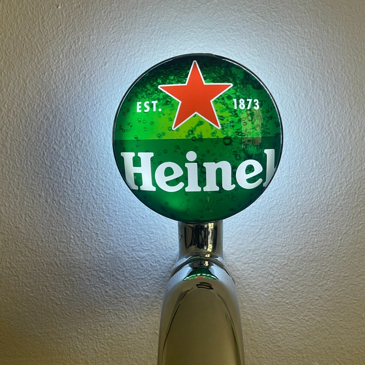 Heineken badge lit up on a beer tap