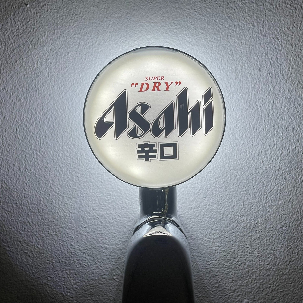 Asahi Super Dry badge lit up on a beer tap