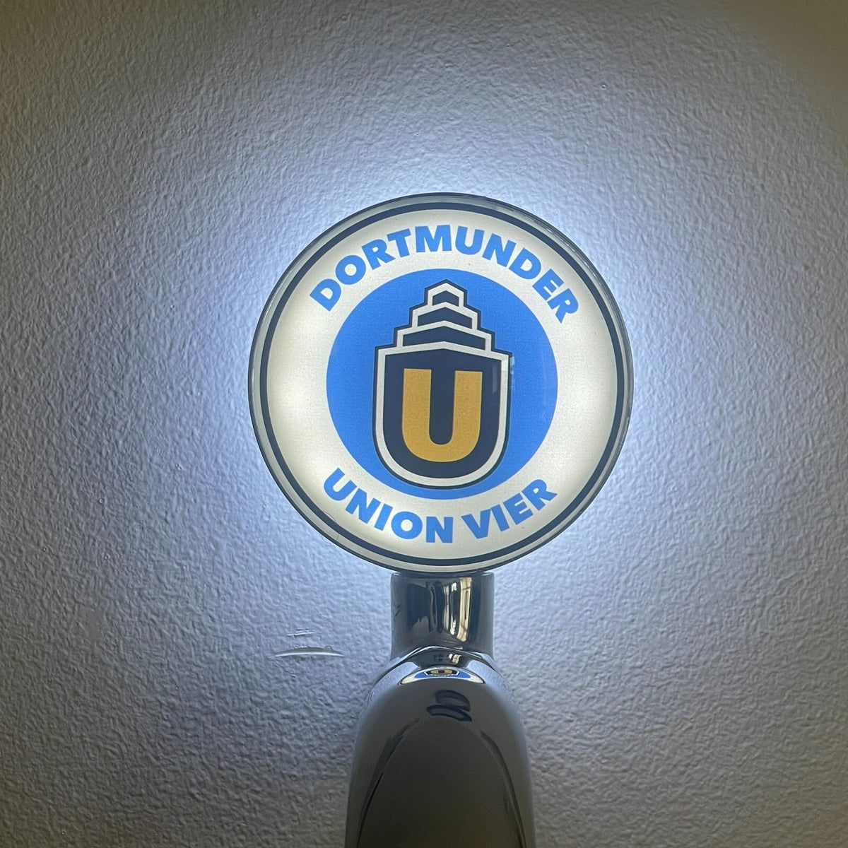 Dortmunder Vier badge lit up on a beer tap