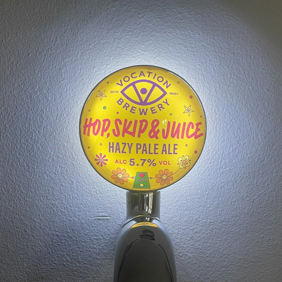 Vocation Hop, Skip & Juice badge lit up on a beer tap
