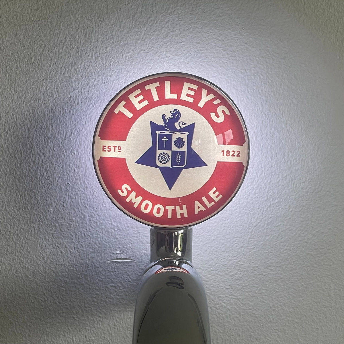 Tetley's Smooth Ale badge lit up on a beer tap