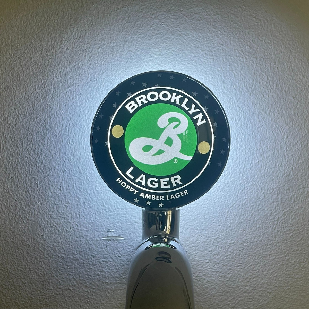 Brooklyn Lager badge lit up on a beer tap