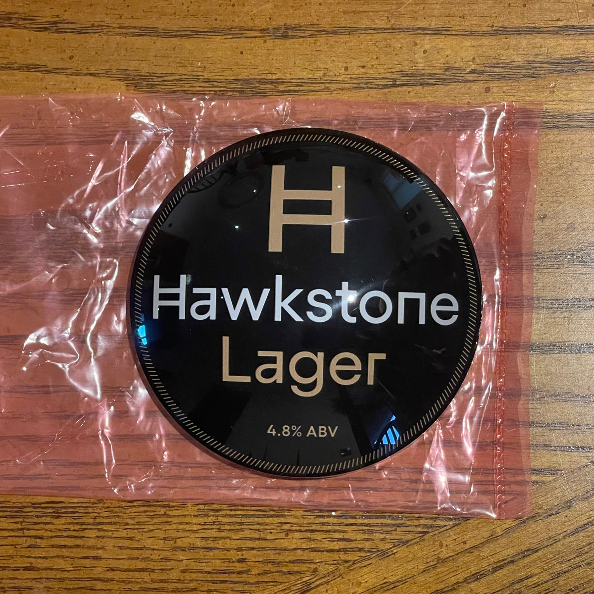 Hawkstone Lager badge in its packaging