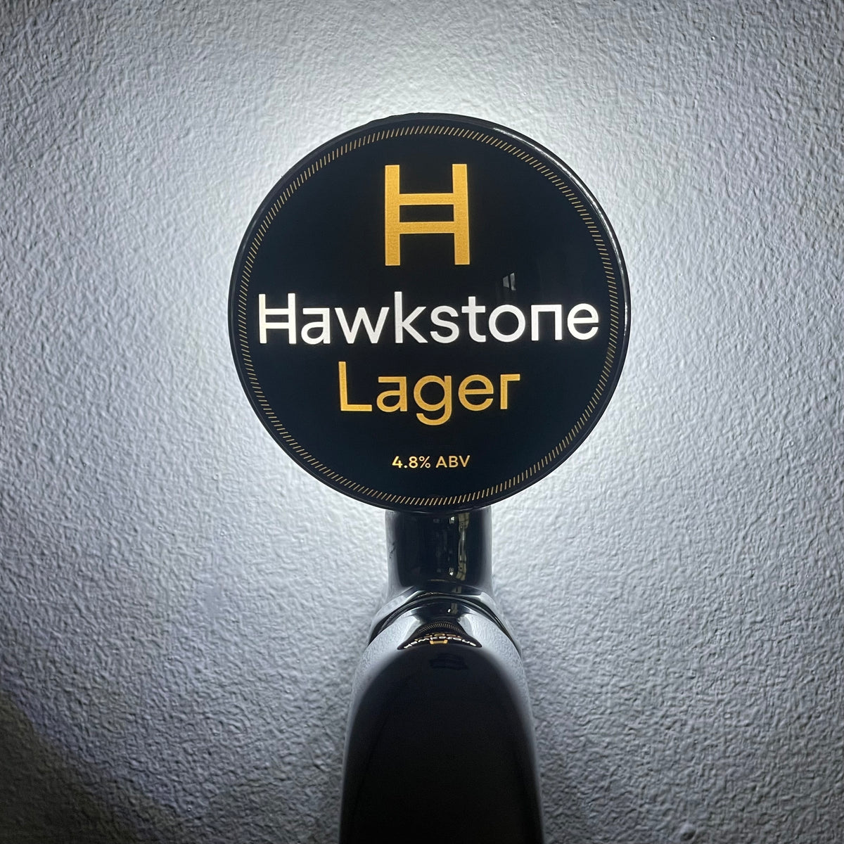 Hawkstone Lager badge lit up on a beer tap